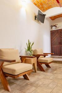 a room with chairs and a table and a tv at QUINTA BERNAL in Lo de Marcos