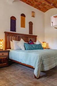 ein Schlafzimmer mit einem Bett mit blauen Laken und Kissen in der Unterkunft QUINTA BERNAL in Lo de Marcos