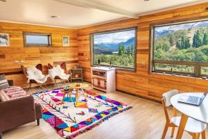 塞羅堡別墅的住宿－B&B y Cabañas Cerro Castillo，客房设有木墙和带桌椅的窗户。