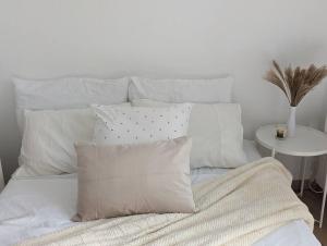 un letto bianco con cuscini bianchi e un tavolo di 2 Bedroom for 4-6, only 10’ by car from Paris. a Chilly-Mazarin