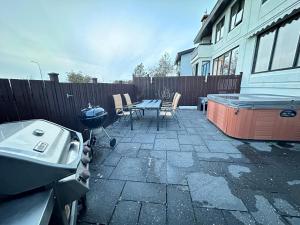a backyard with a grill and a table and a hot tub at House in Reykjavik - Birta Rentals in Reykjavík