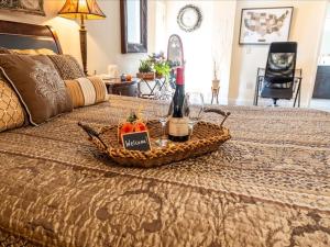 - une bouteille de vin et une corbeille de fruits sur le lit dans l'établissement College Park-Orlando 5Star Oasis - QUIET Neighborhood-PRIVATE-Free Parking-mins from EOLA,DT, Winter Park, à Orlando