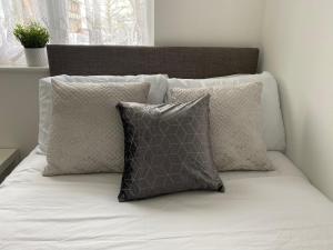 1 cama blanca con 3 almohadas en Entire Home, Long Stay, Contractors, Relocators - LGW, en Horley