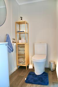 La salle de bains est pourvue de toilettes et d'un tapis bleu. dans l'établissement The Bird House Tiny Home, à Ngaruawahia