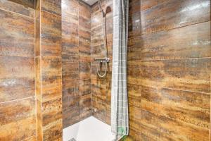 y baño con paredes de madera y ducha. en Cozy Penthouse, 20 min to downtown, Alcalá Norte, en Madrid