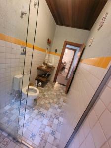 La salle de bains est pourvue de toilettes et d'une douche à l'italienne. dans l'établissement Sítio Vale da Cachoeira, à Pôrto Firme