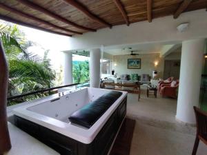 a large living room with a bath tub on a patio at PLAYA PRIVADA del desarrollo in Ixtapa