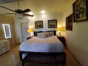 a bedroom with a large bed and a ceiling fan at PLAYA PRIVADA del desarrollo in Ixtapa