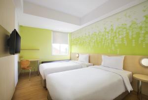 Un pat sau paturi într-o cameră la Zest Bogor by Swiss-Belhotel International
