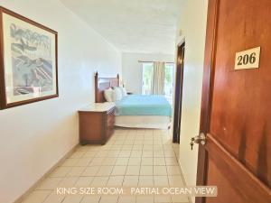 1 dormitorio con 1 cama y 1 dormitorio con puerta en Selva Boutique Hotel - Luquillo Oceanfront Retreat, en Luquillo