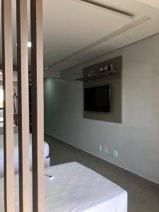 a room with a bed and a tv on a wall at Garvey Hotel - Flat centro de Brasília in Brasilia +3 photos