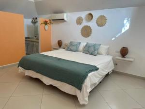 een slaapkamer met een groot wit bed met blauwe kussens bij Las Terrenas Villa- King Bed, Beaches & Dining in Las Terrenas