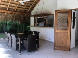 een eetkamer met een tafel en stoelen en een houten deur bij Las Terrenas Villa- King Bed, Beaches & Dining in Las Terrenas