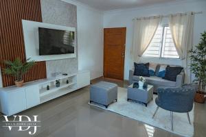 a living room with a couch and a tv at Rooftop with Pool, La Romana, Villa Doña Julia in La Romana
