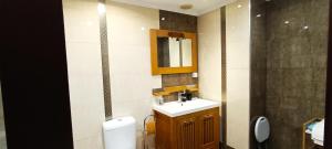 a bathroom with a sink and a mirror and a toilet at Reis Magos Beach Caniço Sea line Apartment in Caniço +29 photos