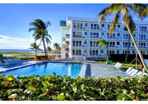 ein Hotel mit einem Pool vor einem Gebäude in der Unterkunft Discover the Charm and the Sea Gardens, an Exceptional Gold Coast Studio Condo Retreat - Special Offer Now! in Pompano Beach