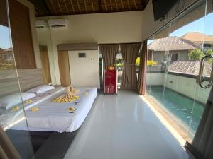 1 dormitorio con cama y piscina en Bali Golden Elephant Boutique Villa, en Jimbaran