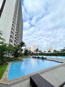 a large swimming pool in front of a tall building at Livingatri - Skyhouse BSD next to AEON near ICE BSD in Tjilandak