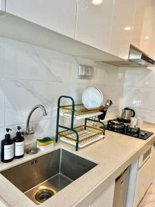 a kitchen with a sink and a counter top at Livingatri - Skyhouse BSD next to AEON near ICE BSD in Tjilandak