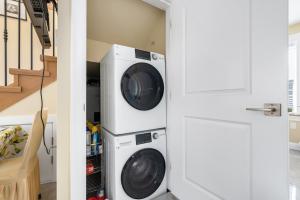 a laundry room with a washer and dryer next to a staircase at Three bedrooms brand new laneway house near public transit in Vancouver