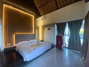 a bedroom with a large bed in a room at Bali Golden Elephant Boutique Villa in Jimbaran