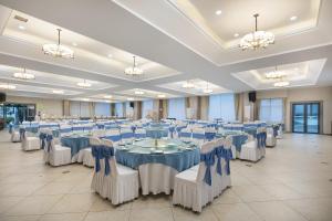 a large banquet hall with blue and white tables and chairs at NATIONAL SCENIC SPOT SUNSHINE RESORT HOTEL in Zhangjiajie