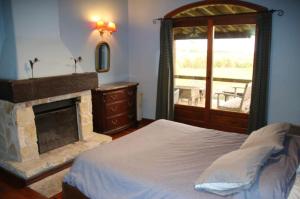 1 dormitorio con 1 cama con chimenea y ventana en Country Laguna El Rosario - Pinamar en Pinamar