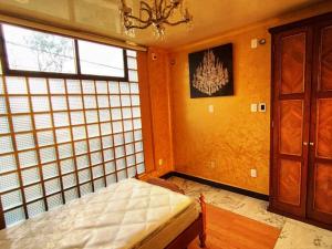una camera con un letto in una stanza con finestre di Entre las Lomas de Chapultepec y Santa Fe a Città del Messico