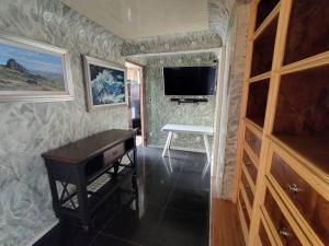 een kamer met een piano en een tv aan de muur bij Entre las Lomas de Chapultepec y Santa Fe in Mexico-Stad