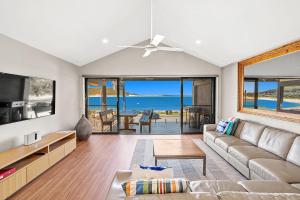 a living room with a couch and a tv at Beach Duplex 72 Marine Dr - Fingal Bay in Fingal Bay