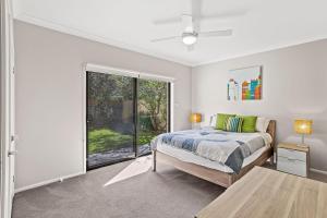 a bedroom with a bed and a window at Beach Duplex 72 Marine Dr - Fingal Bay in Fingal Bay