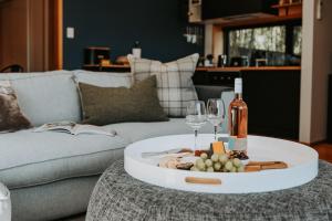 uma mesa com uma garrafa de vinho e copos de vinho em Finnview House em Hobart
