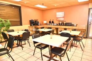 ニューポートにあるFortune Inn & Suitesのテーブルと椅子が備わるレストラン
