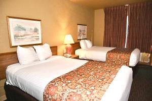 ニューポートにあるFortune Inn & Suitesのベッド2台と窓が備わるホテルルームです。