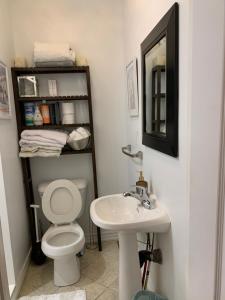 a bathroom with a toilet and a sink and a mirror at Comfortable Cozy and Convenient rooms for rent in Toronto