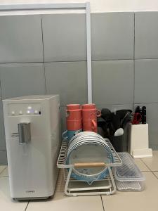 uma cozinha com um suporte para secar pratos ao lado de um frigorífico em SDC Suite Home em Lahad Datu
