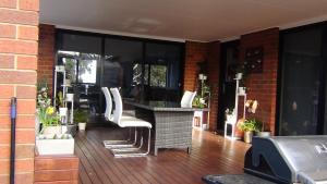 a patio with a table and white chairs at Tranquil Retreat 10 Min to Hobart-WIFI Smart TV in Hobart