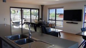 a kitchen with a sink and a living room at Tranquil Retreat 10 Min to Hobart-WIFI Smart TV in Hobart