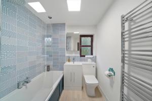 a bathroom with a tub and a toilet and a sink at Beautiful 5 bedroom house in Stone, Aylesbury, Free parking in Stone