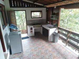 a kitchen with a stove and a sink in a house at Treetop Guesthouse and Bungalows in Sabang