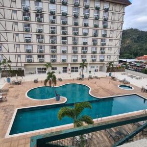 a hotel with a pool in front of a building at Granja Brasil - Itaipava in Petrópolis