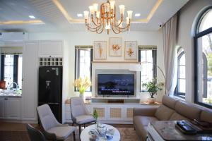 a living room with a couch and a tv at Le Gia Villa 1, sang trọng, bên hồ, hướng biển, 3PN, 3 phòng tắm, Novaworld Phan Thiết cho kỳ nghỉ gia đình in Phan Thiet