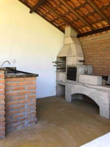 eine Küche mit Backofen und Ziegelwand in der Unterkunft Fazenda Vô Azarias in Visconde De Maua