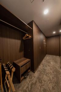 a room with a wooden wall with a closet and a bench at Iroha Grand Hotel Kintetsu Nara Ekimae in Nara
