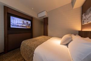 Habitación de hotel con cama y TV de pantalla plana. en Iroha Grand Hotel Kintetsu Nara Ekimae, en Nara