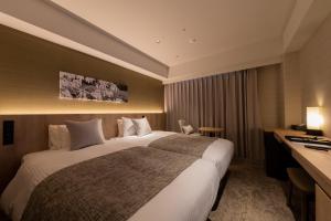 um quarto de hotel com uma cama grande e uma secretária em Iroha Grand Hotel Kintetsu Nara Ekimae em Nara