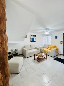 a living room with two couches and a table at La Casa del Capi in Cancún