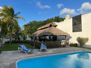 two chairs and a umbrella next to a swimming pool at La Casa del Capi in Cancún