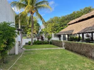 a house with a grass roof and a yard at La Casa del Capi in Cancún
