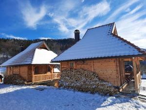 a log cabin with snow on the roof at Draganovi Konaci in Zaovine
